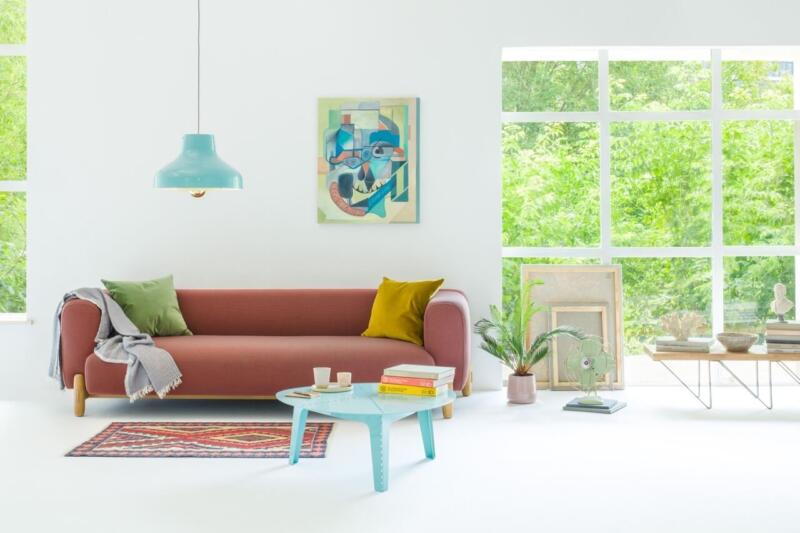 Jasny salon z kolorowymi akcentami i designerskimi meblami.