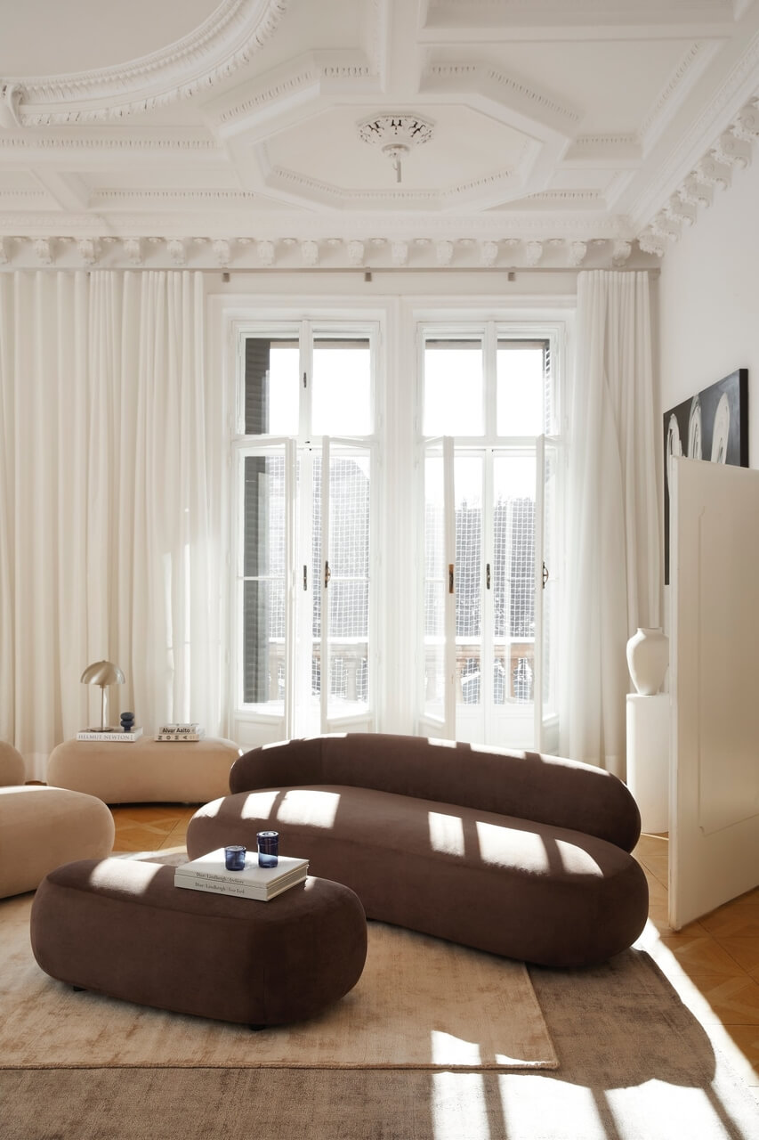 Elegancki salon z nowoczesnymi sofami i detalami sztukaterii.