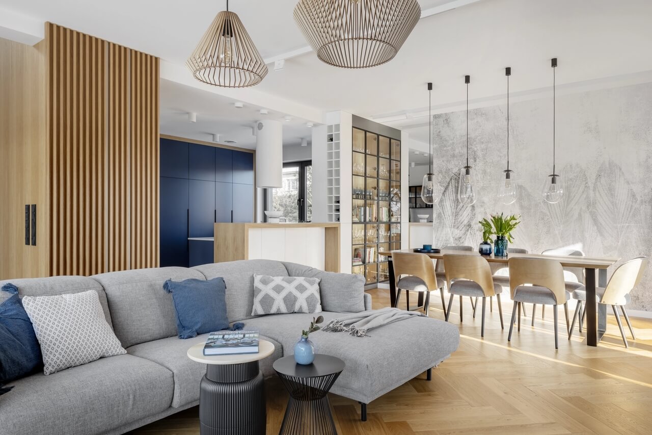Nowoczesny salon z drewnianymi akcentami i stylowymi lampami.