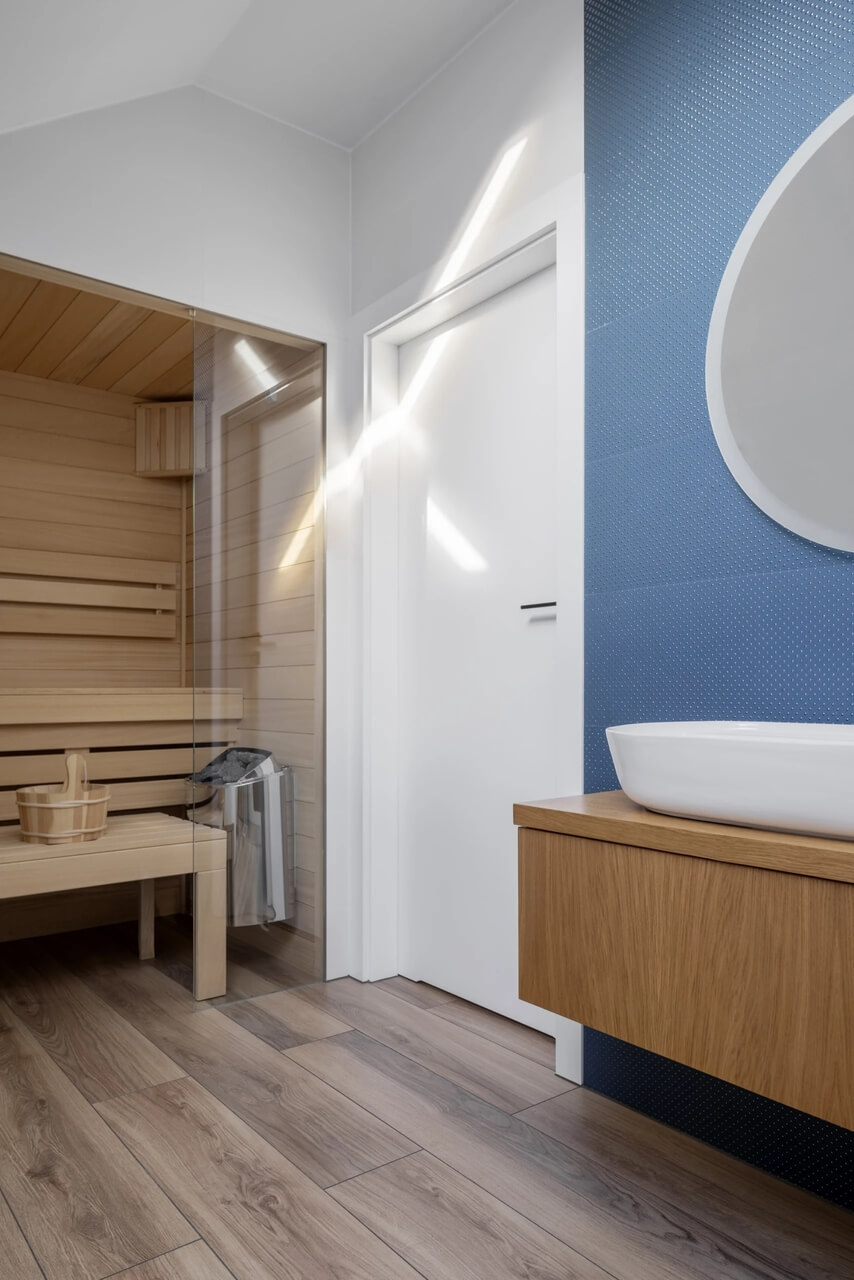 Sauna z drewnem i nowoczesną umywalką w minimalistycznym stylu.