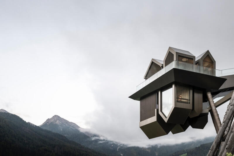 Nowoczesna architektura na tle górskiej panoramy.