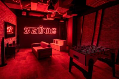 Stylowa sala gier z czerwonym oświetleniem i neonowym napisem.
