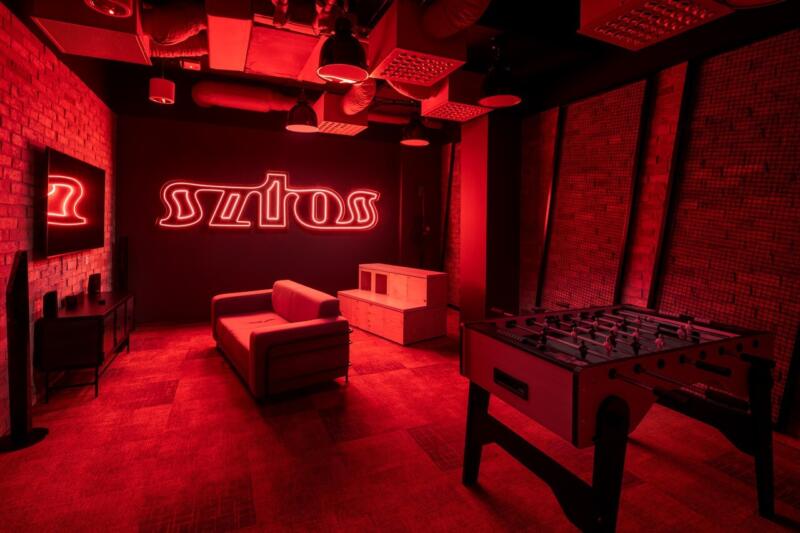 Stylowa sala gier z czerwonym oświetleniem i neonowym napisem.
