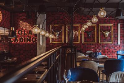 Stylowa restauracja z czerwonymi kaflami i designerskimi lampami.
