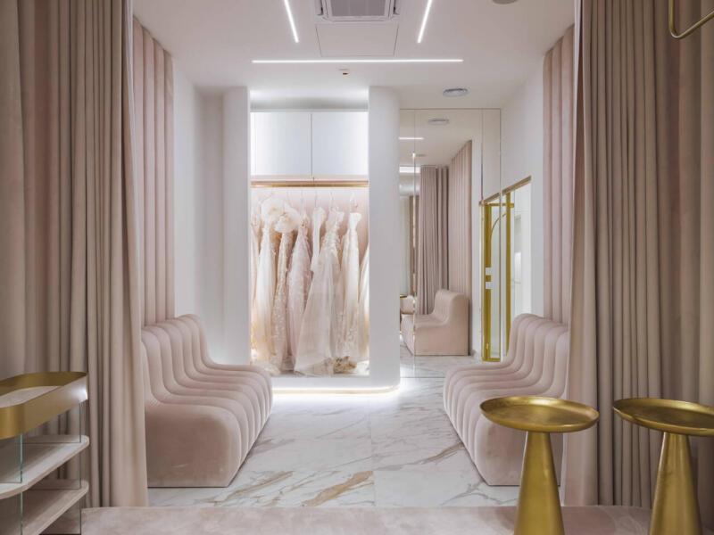 Nowoczesny salon ślubny z eleganckimi sukniami i stylowym wystrojem.