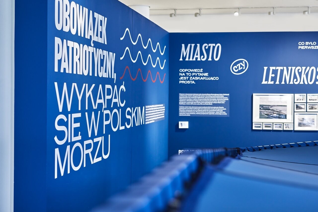 Niebieska wystawa z tekstem o architekturze i designie miejskim.