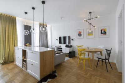 Biała kuchnia z niebieskimi frontami w warszawskim apartamencie projektu MADAMA