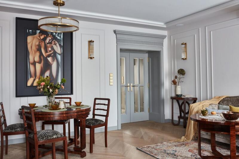 Elegancki salon z drewnianym stołem i stylowym obrazem na ścianie.