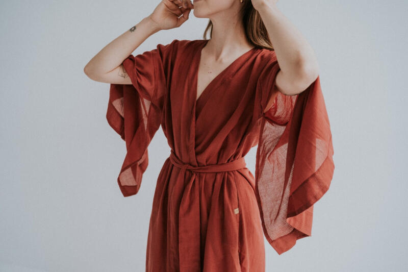 Osoba w eleganckiej sukience z szerokimi rękawami, styl boho.