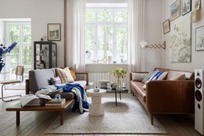 Przytulny salon z designerskimi meblami i dużymi oknami, idealny na relaks.