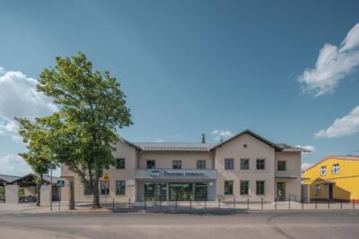 Dworzec kolejowy z nowoczesną architekturą i zielenią.