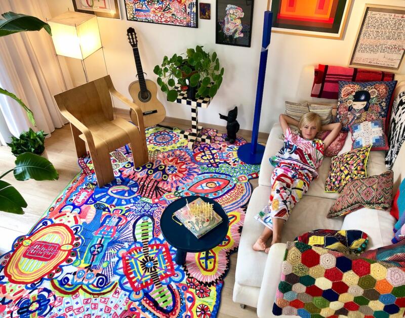 Colorowy salon z fotelem, gitarą i dzieckiem na sofie relaksuje.