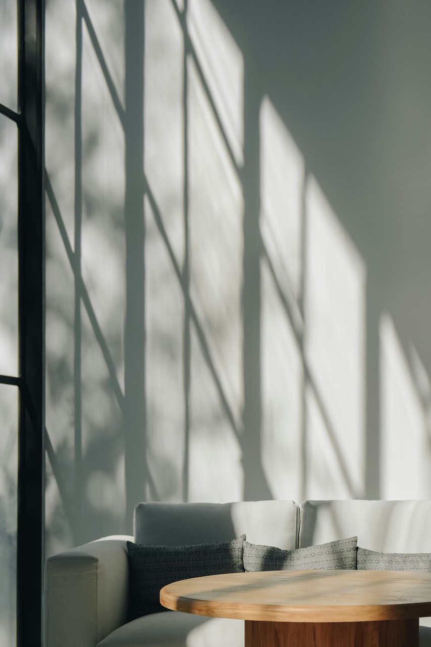 Przytulna sofa w minimalistycznym wnętrzu z drewnianym stołem.