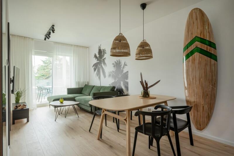 Współczesny salon z zieloną kanapą i dekoracją w stylu boho.