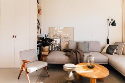 Przytulny salon z designerskimi meblami i roślinami.