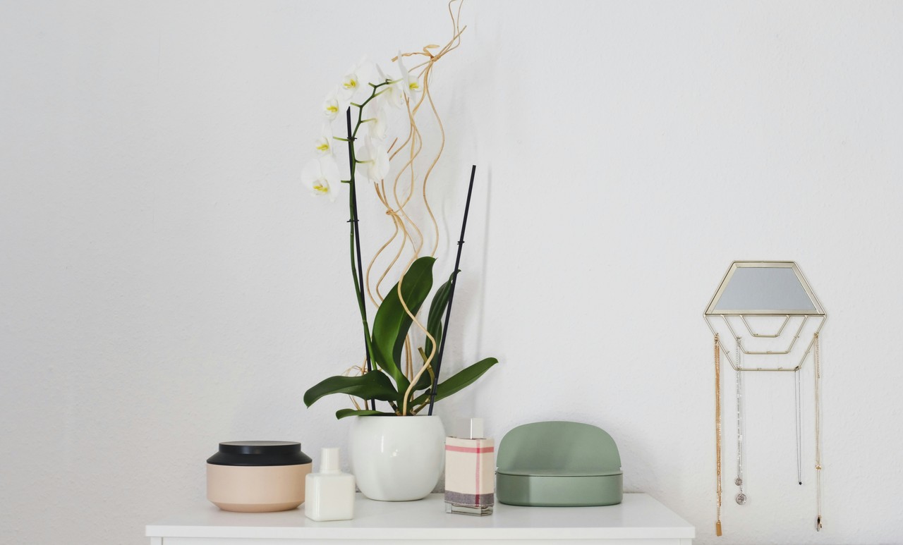 Minimalistyczny wystrój z białą orchideą i eleganckimi akcesoriami.