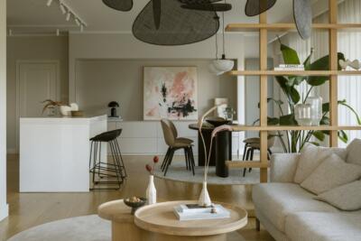 Nowoczesny salon z roślinami i designerskimi akcentami.
