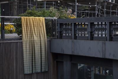 Żółta tkanina na tle industrialnej architektury miejskiej, piękne.