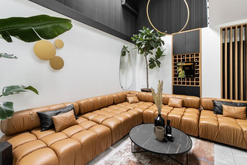 Przytulny salon z brązową sofą i stylowymi dekoracjami.