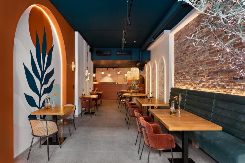 Przytulna restauracja z ceglaną ścianą i nowoczesnym wystrojem. Idealna przestrzeń na relaks.