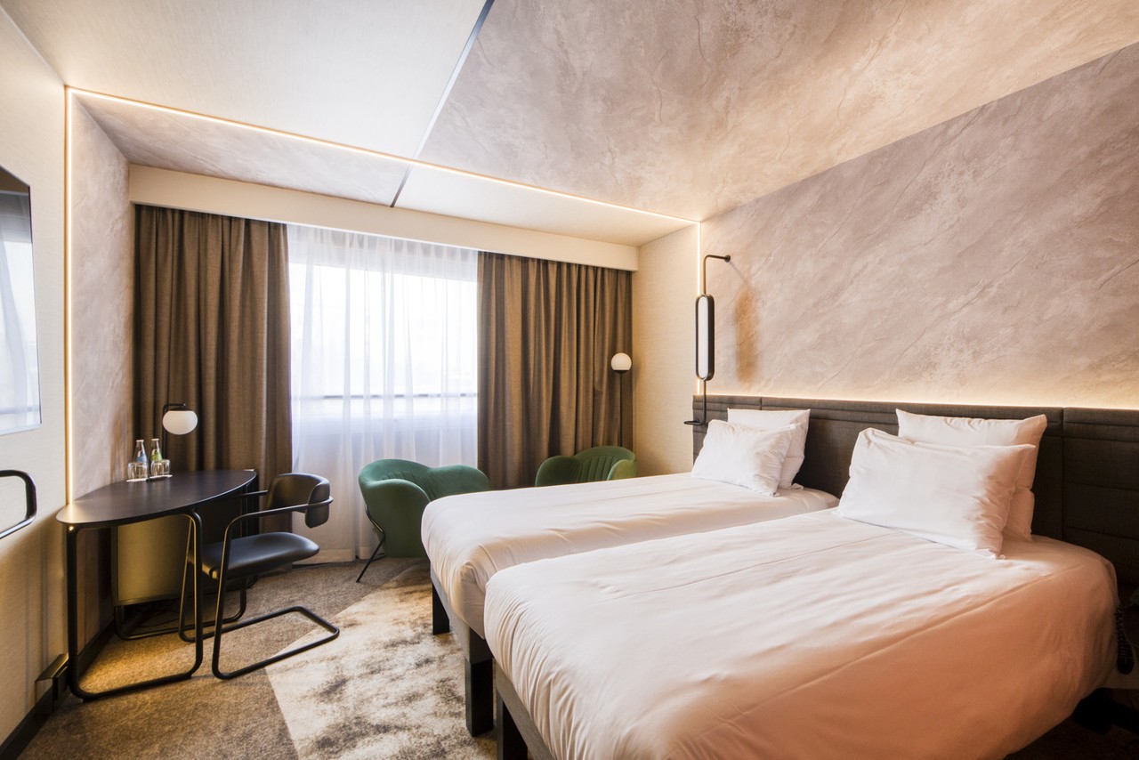 Elegancki pokój hotelowy z nowoczesnym oświetleniem i stylowymi meblami.
