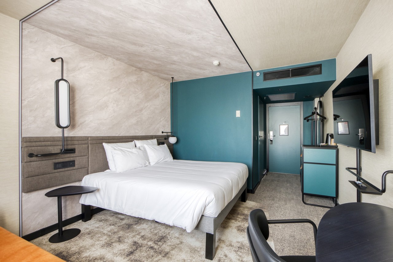 Minimalistyczny pokój hotelowy z eleganckim wystrojem i stonowanymi barwami.