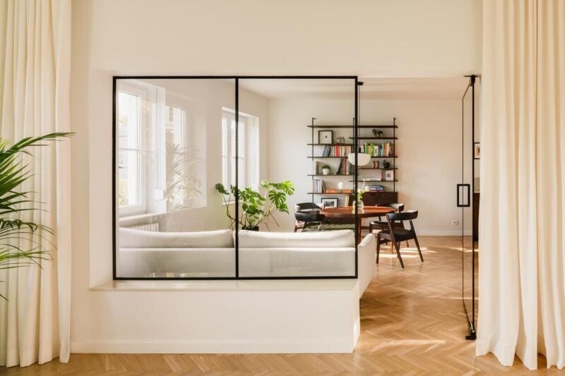 Przestronny salon z przeszkloną ścianą i eleganckimi detalami.