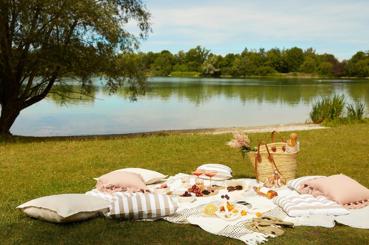 Alt: Romantyczny piknik nad wodą, elegancki wystrój i natura.