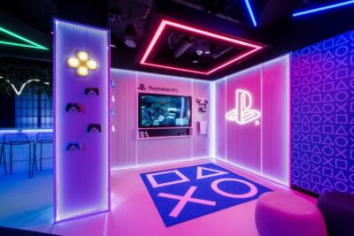 Neonowy salon gier z designerskimi elementami PlayStation.