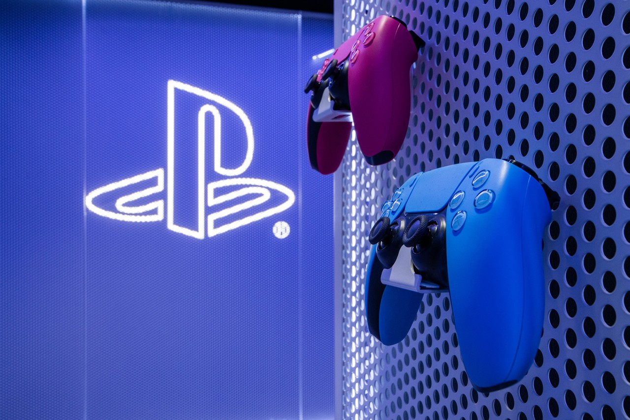 Futurystyczne wnętrze z kontrolerami i logo PlayStation.