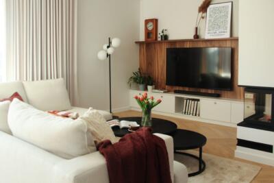 Nowoczesny salon z drewnianą ścianą i przytulnym wystrojem.