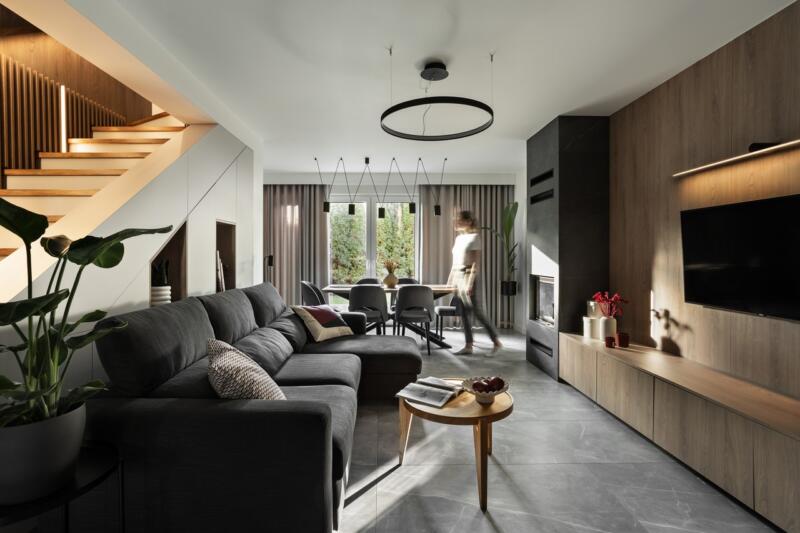 Nowoczesny salon z designerską sofą i eleganckim oświetleniem.