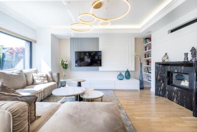 Nowoczesny salon z elegancką sofą i designerskim oświetleniem.