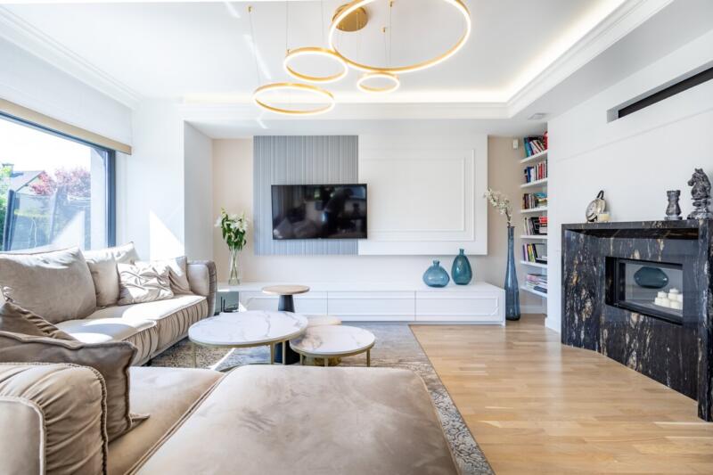 Nowoczesny salon z elegancką sofą i designerskim oświetleniem.