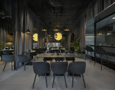 Nowoczesna restauracja z designerskim oświetleniem, elegancja w szarości.