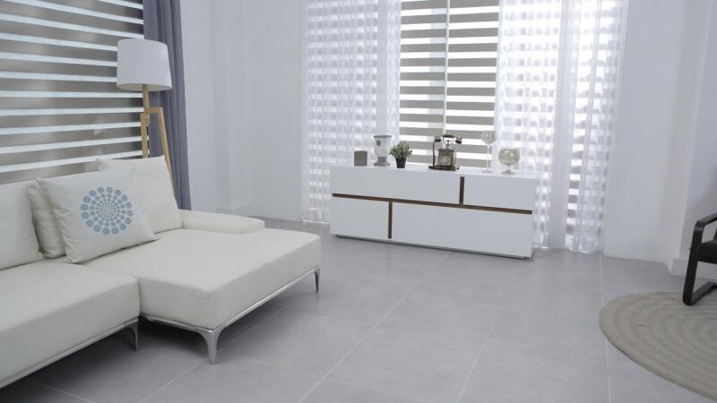 Nowoczesny salon z białą sofą i elegancką komodą.