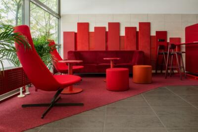 Nowoczesny salon w czerwieni z designerskimi fotelami.
