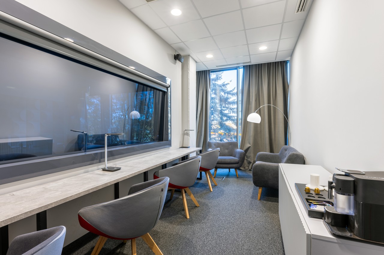Nowoczesne biuro z designerskimi fotelami i eleganckim oświetleniem.