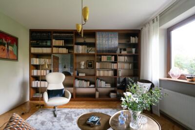 Przytulne wnętrze z elegancką biblioteką. Ciepły klimat.