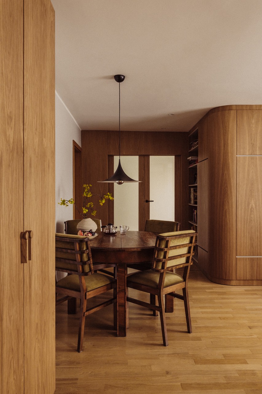 Elegancka jadalnia z drewnianym stołem i designerską lampą.