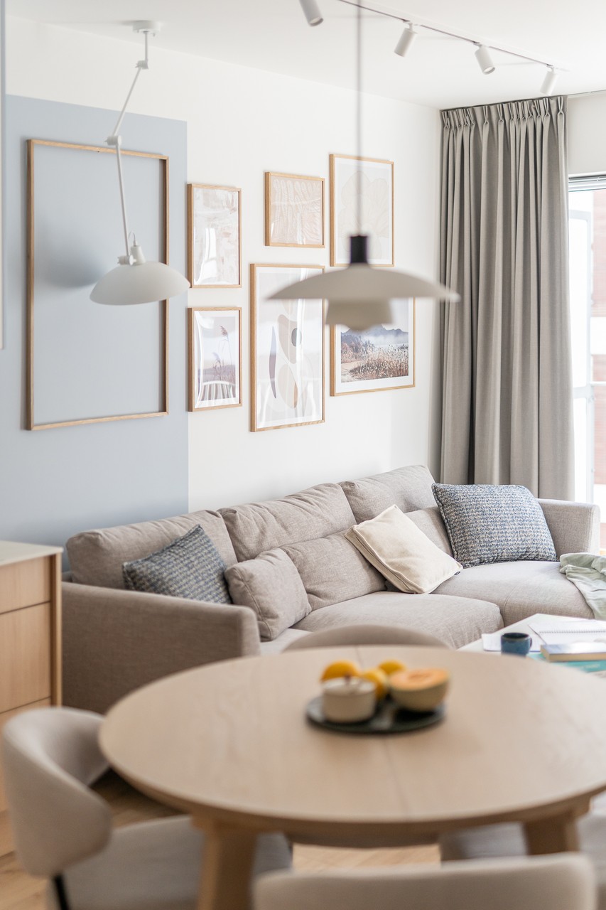 Cosy living room with wall decoration, large sofa and elegant lighting.