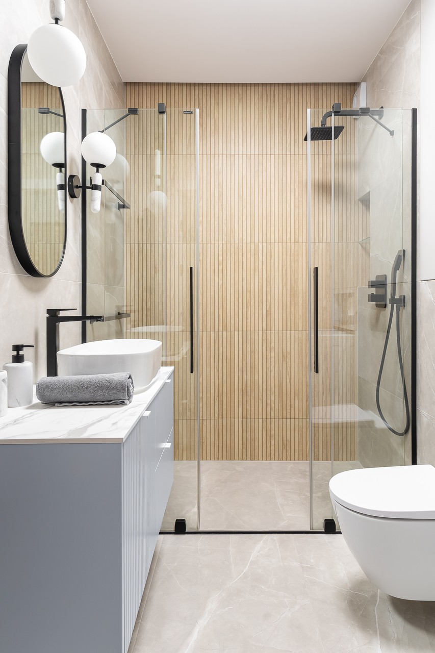 Modern bathroom with shower, wooden accents and elegant ceramics.