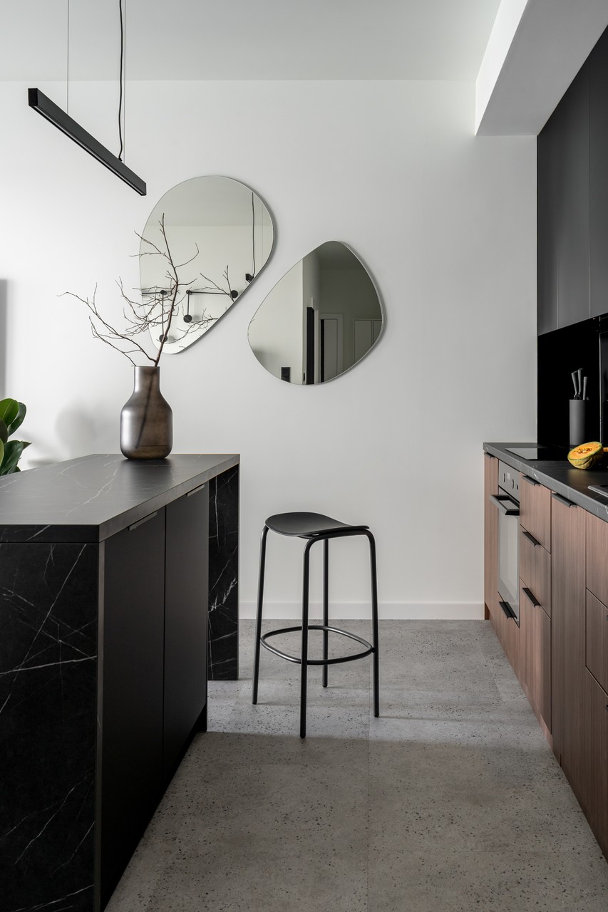 Modern kitchen with black details and designer mirrors.