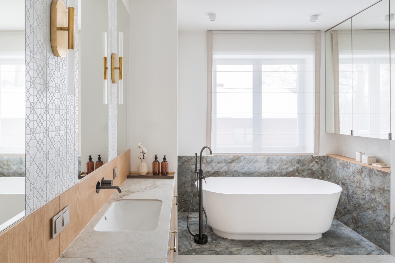 Modern bathroom with bath, marble details and stylish lighting.