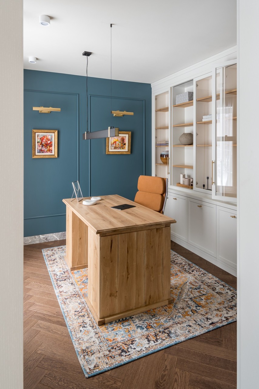 Elegant office with wooden desk and navy blue wall.