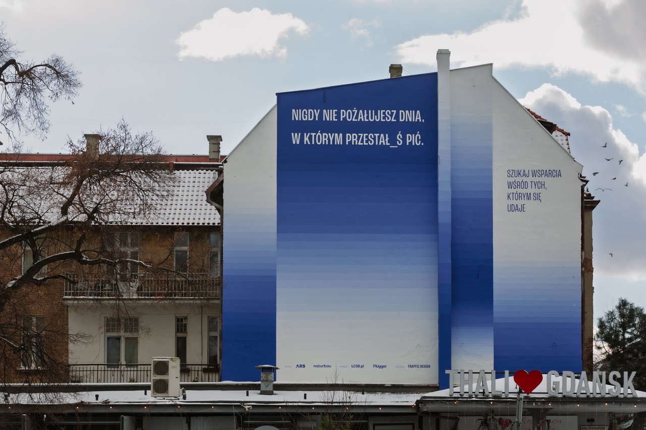 Mural z gradientem niebieskim na ścianie budynku w Gdańsku.