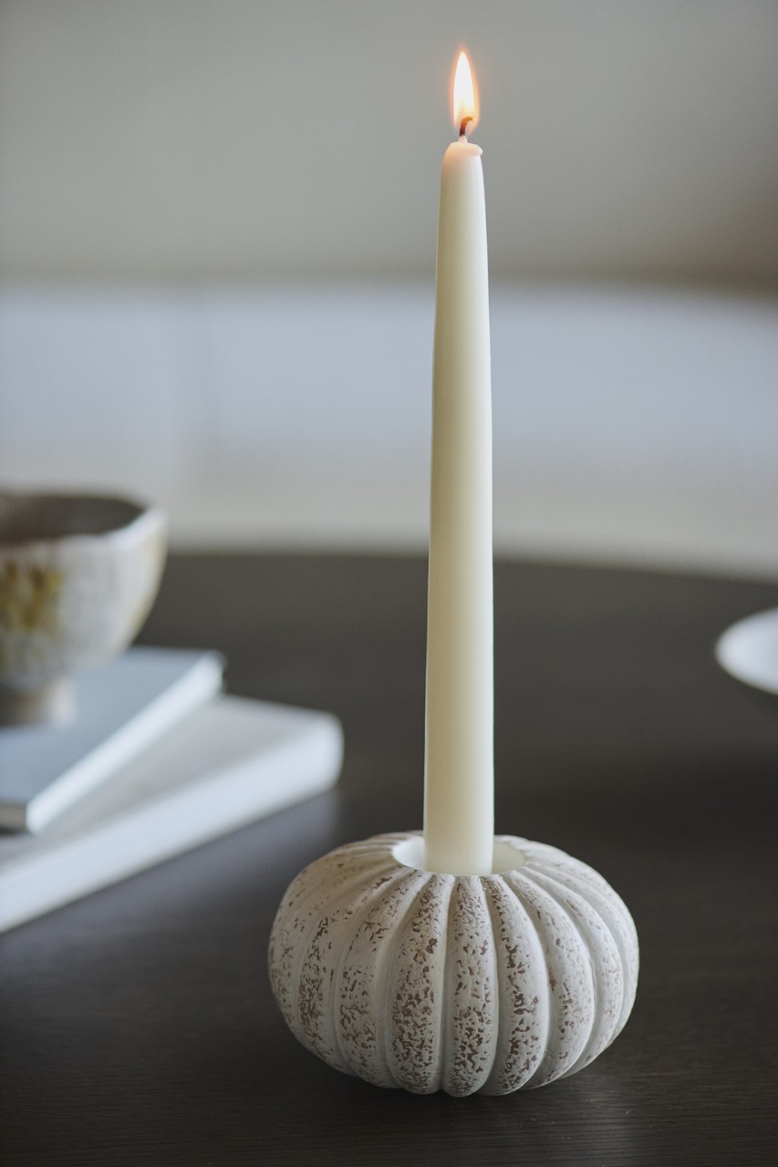 Stylowa świeca w eleganckim ceramicznym świeczniku.