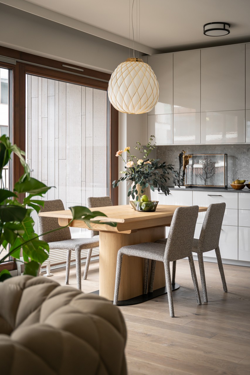 Nowoczesna jadalnia z drewnianym stołem i designerską lampą.