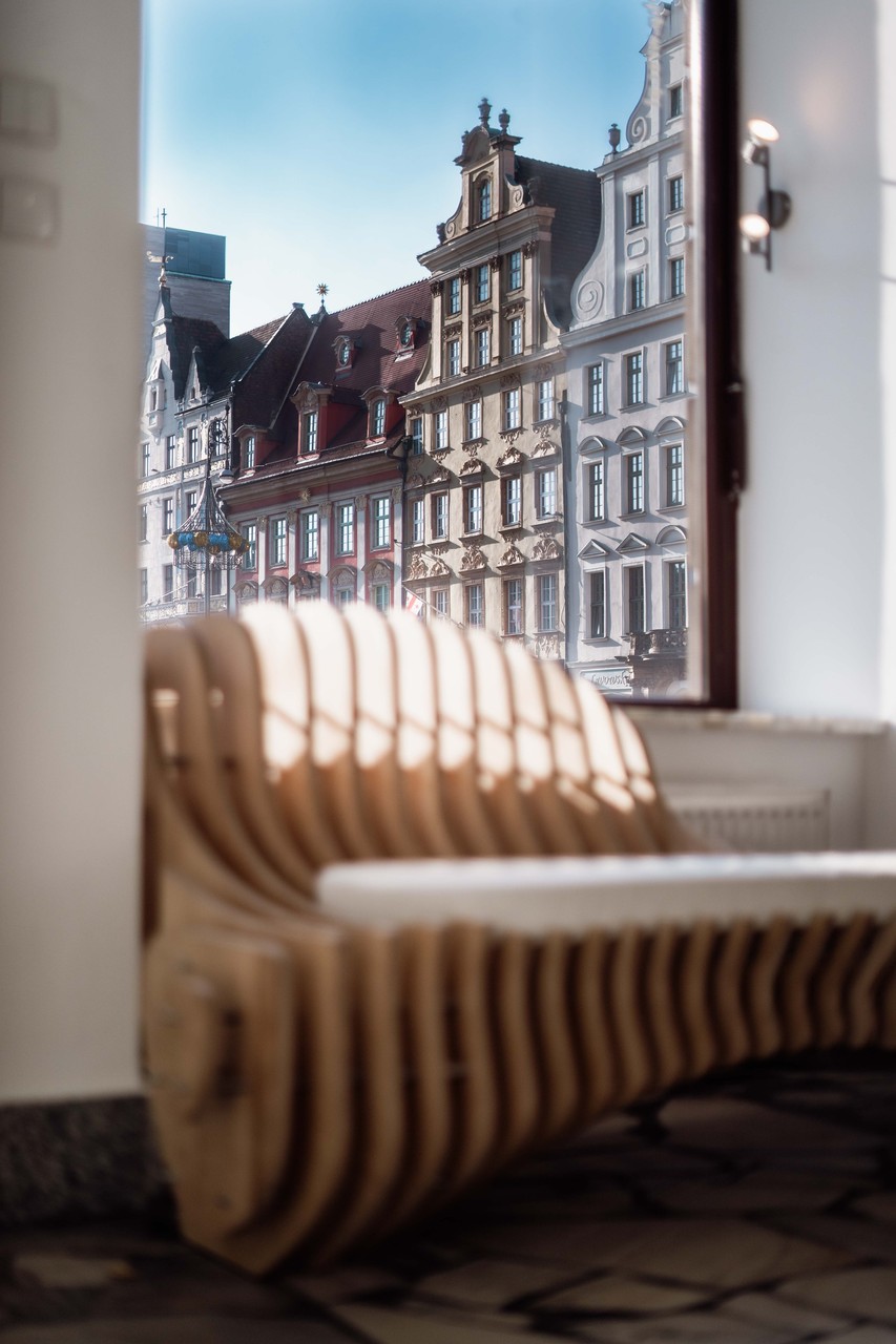 Zabytkowa architektura za stylową drewnianą ławką.