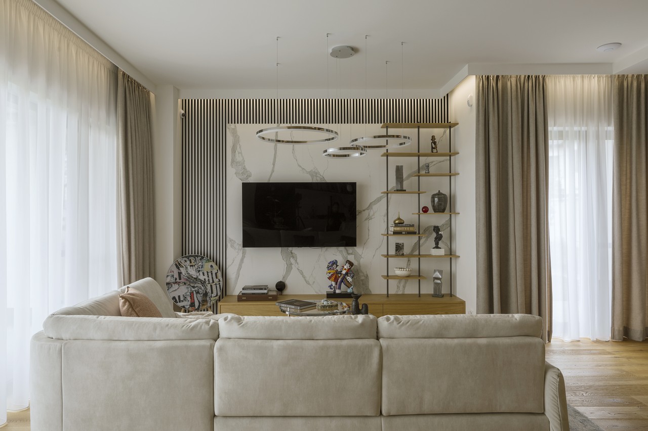 Elegancki salon z designerskim oświetleniem i nowoczesnymi półkami.
